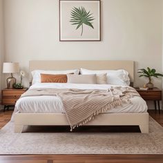 a bedroom with a bed, nightstands and pictures on the wall above it is shown