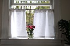 a vase filled with flowers sitting on top of a window sill