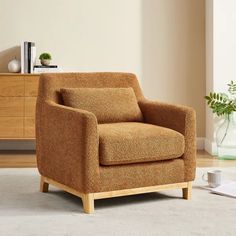 a brown chair sitting on top of a carpeted floor next to a wooden dresser