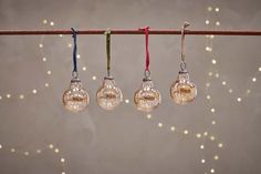 three light bulbs hanging from a string with lights in the background