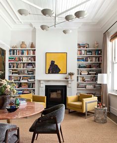 a living room filled with furniture and a fire place under a painting on the wall