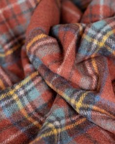 an orange and blue checkered blanket laying on top of a bed