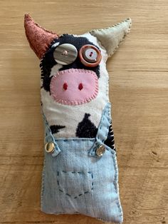 a stuffed cow is sitting on the floor with buttons in it's eyes and nose