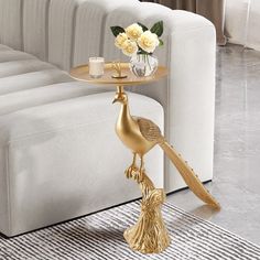 a golden bird shaped table with flowers on it