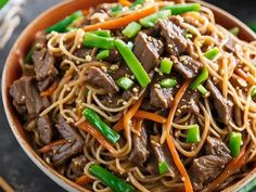 a bowl filled with beef and noodles on top of a table