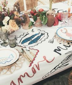 the table is set with plates and vases on it, along with other decorations