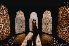 a person standing in front of an array of lit up archways with lights on them