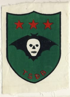 a patch with a skull and bats on it's side, in the shape of a shield