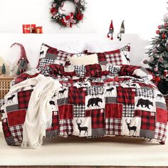 a christmas themed bedroom with red and black plaid bedding, wreaths and trees