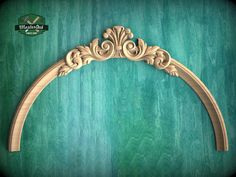 a wooden arch with an ornate design on the top and bottom, against a green background