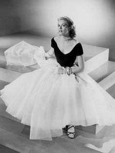 a black and white photo of a woman in a tulle dress with her hands on her hips