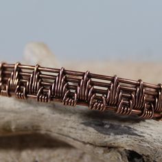 a piece of copper wire sitting on top of a rock