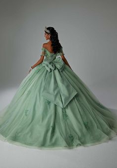 a woman in a green ball gown standing on a white background