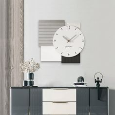 a white clock mounted to the side of a wall next to a black and white cabinet