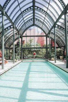 an indoor swimming pool in the middle of a building with lots of glass on it