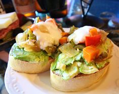 an open face sandwich with avocado, tomatoes and sour cream on the side