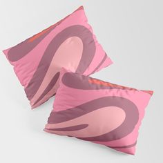 two pink and brown pillows on top of each other with an abstract design in the middle