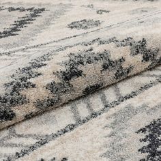 an area rug is shown with black and white designs on the carpet, as if it were made from wool or polyester