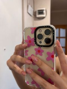 a woman holding up her phone case with pink flowers on the front and bottom cover