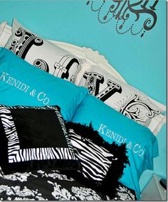 three pillows are stacked on top of each other in front of a blue wall with black and white designs