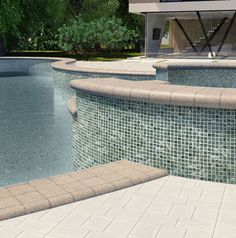 an empty swimming pool with tiled walls and steps leading up to the water's edge