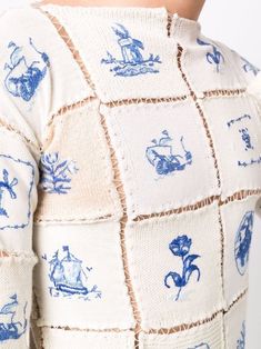 the back of a woman's sweater with blue and white images all over it