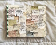 an open notebook covered in lots of different types of tickets and numbers on a bed