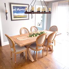 a dining room table and chairs with candles on it