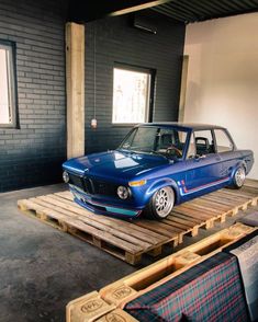 a blue car is parked on top of a pallet