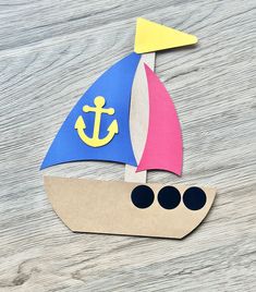 a paper boat with an anchor on the front is cut out to look like a sailboat