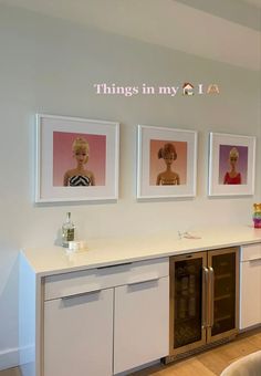 there are three pictures hanging on the wall above a kitchen counter with an oven and dishwasher