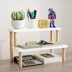 a shelf with books, pens, and other items on it next to a clock