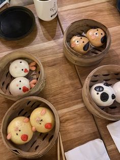 four baskets filled with food sitting on top of a wooden table next to a cup