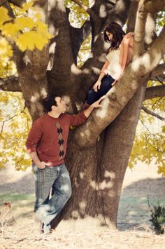 a man and woman climbing up the side of a tree