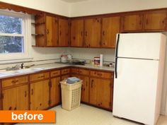 an empty kitchen with wooden cabinets and white refrigerator freezer next to a trash can