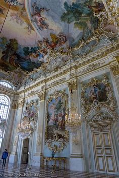 an ornately painted room with chandeliers and paintings