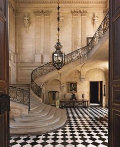 an ornate staircase with black and white checkered flooring