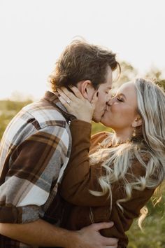 a man and woman kissing each other outside