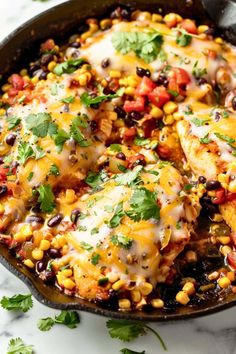 chicken enchilada in a cast iron skillet with cilantro and black beans