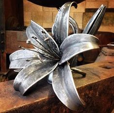 a metal flower sitting on top of a wooden table