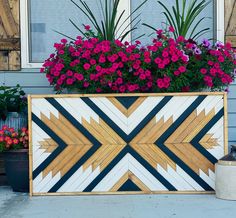 a planter with flowers in it sitting on the side of a building