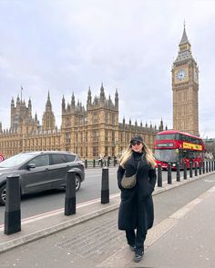 a woman walking down the street in front of big ben