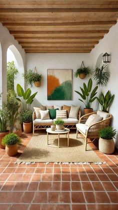 a living room filled with furniture and potted plants on top of a brick floor