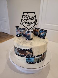 a cake decorated with film strips and photos on it's side, sitting on top of a table