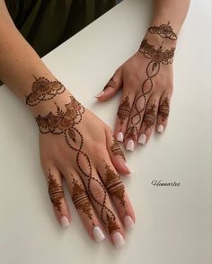 a woman's hands with henna tattoos on them