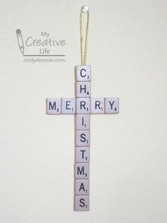 a cross made out of scrabble tiles with the words merry christmas on it