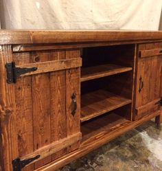 an entertainment center made out of wood with metal pulls on the doors and bottom shelf