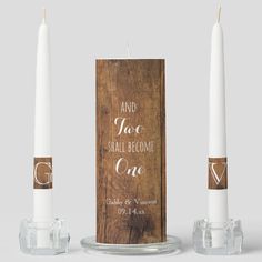 two white candles sitting next to each other on top of a glass holder with the words and you shall become one