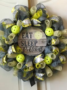 a yellow and gray mesh wreath with some green buttons on it that says eat sleep writeall