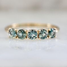 three stone ring in yellow gold with blue topazte and diamonds on the side